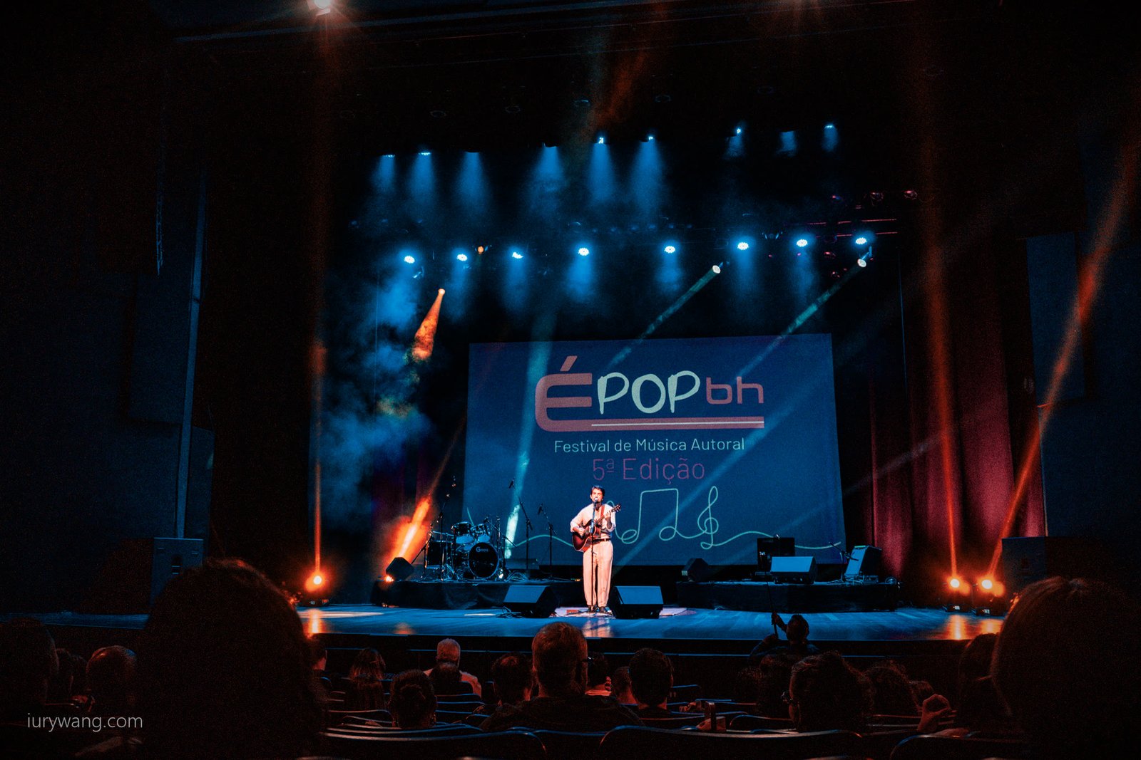 Palco do É POP BH com artista ao violão e telão do festival