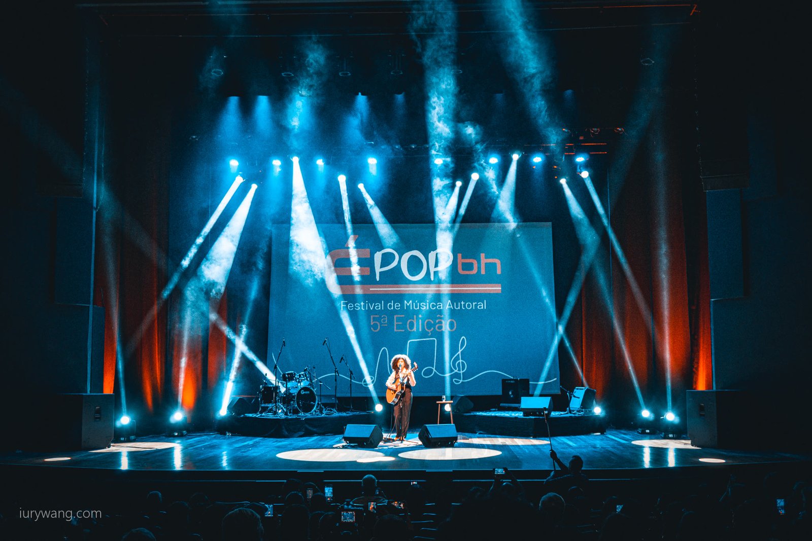 Show no palco do É POP BH com luzes azuis e plateia