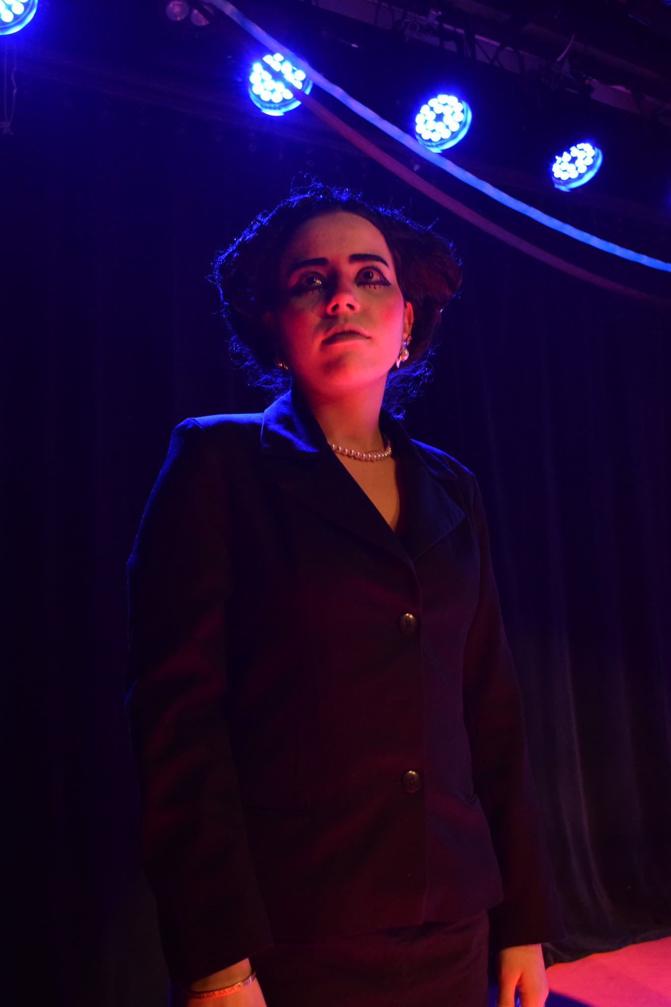 Retrato de atriz de blazer escuro sob luz azul