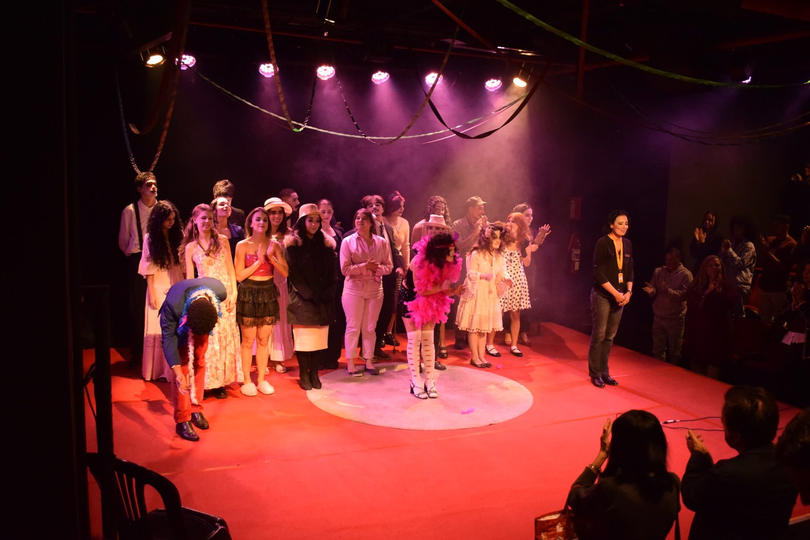 Elenco reunido no palco na cena final da Noite Cênica